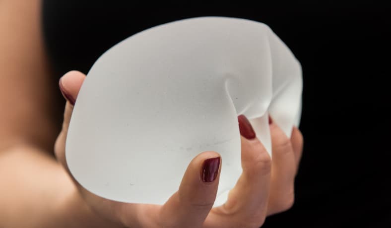 Woman holding breast implant