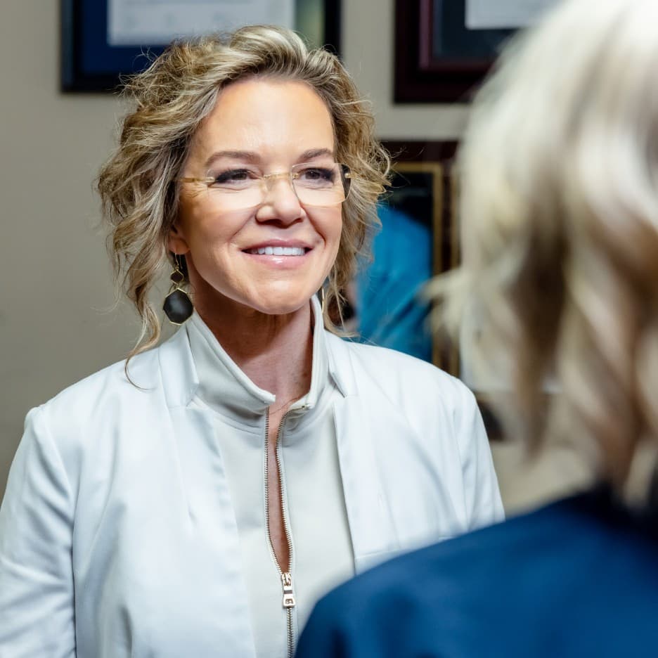 Professional portrait of Holly Casey Wall, MD, FACS smiling in a white coat.