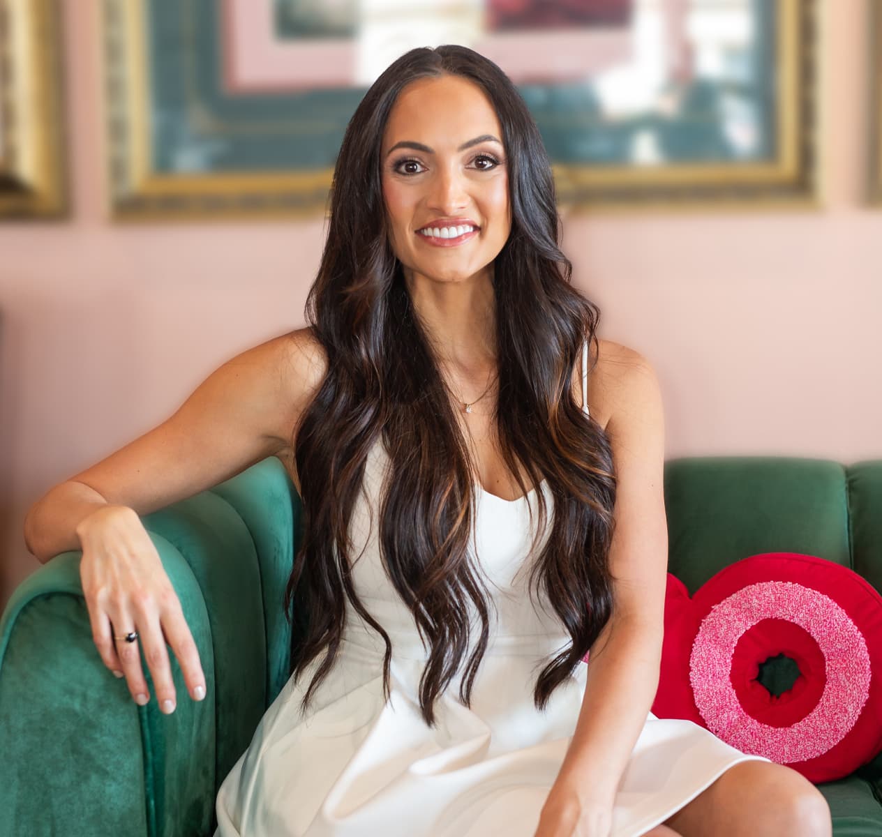 Real patient smiling with long dark hair wearing a white dress
