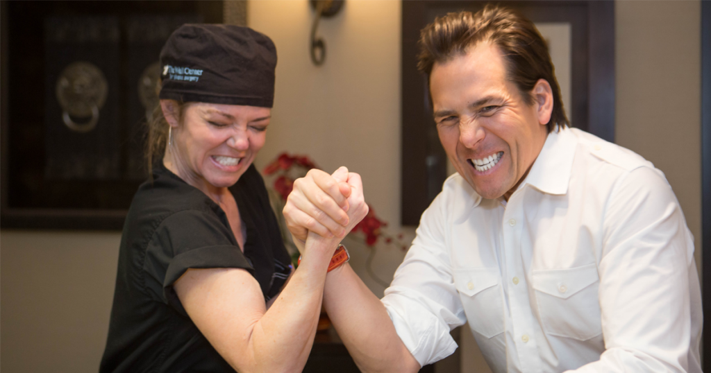 Drs. Holly and Simeon Wall Jr. goofing around arm wrestling