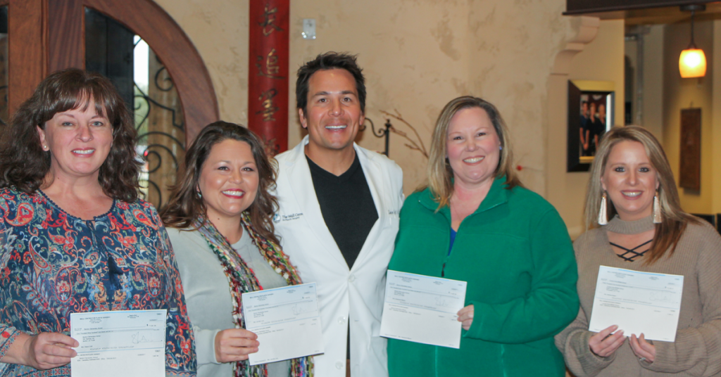 Dr. Simeon Wall Jr. with staff members holding certificates