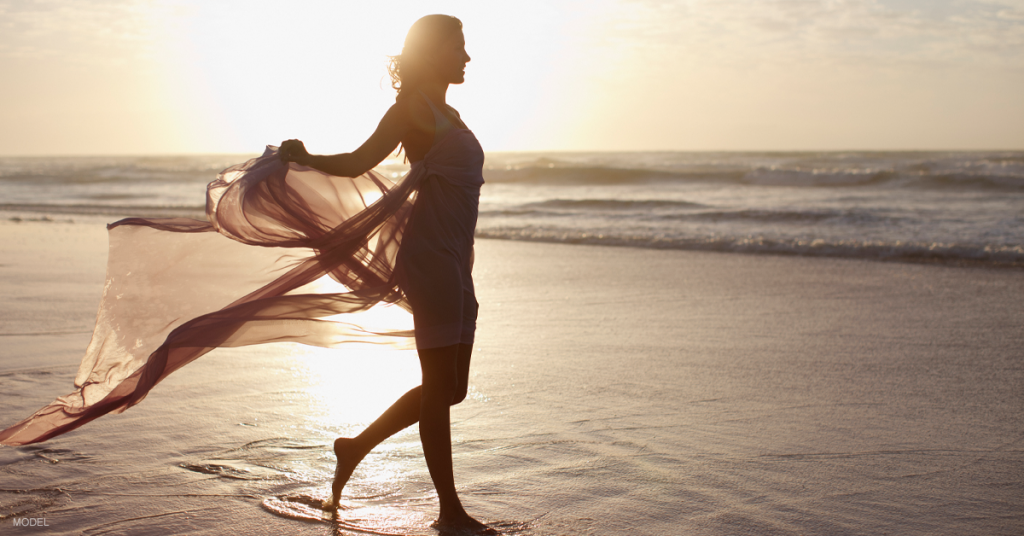 Silhouette of woman walking on beach