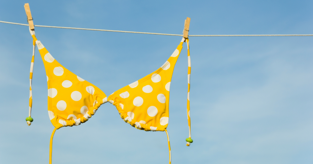 Yellow bikini top with white polka dots hanging from line