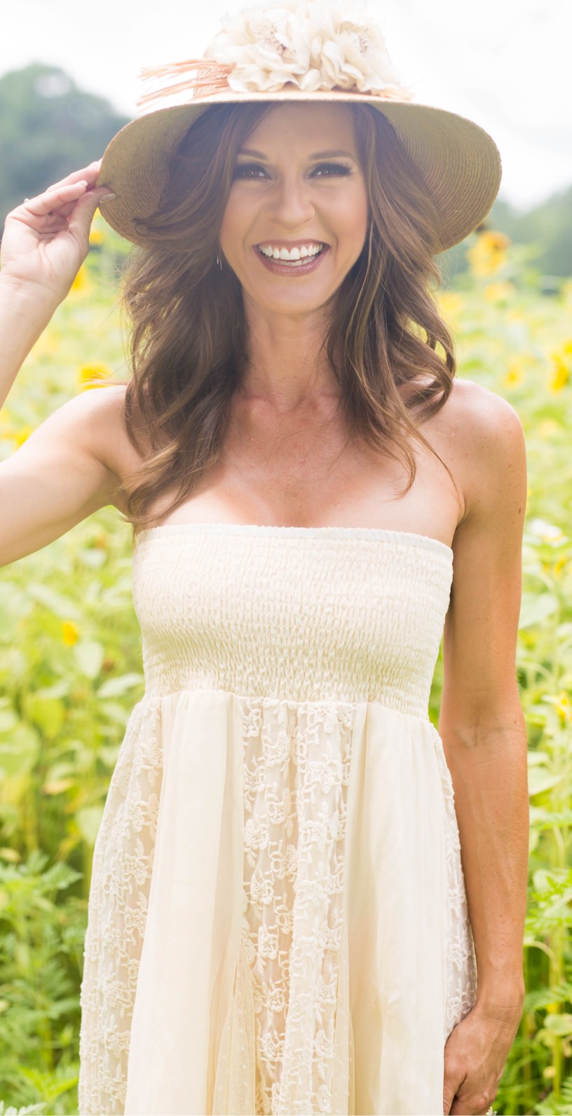 Actual patient wearing sundress and hat in a sunflower field