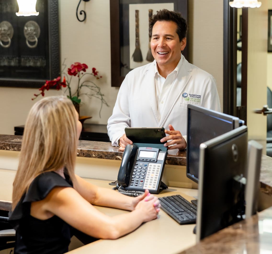 Dr. Simeon Wall Jr. standing at reception desk talking to receptionist