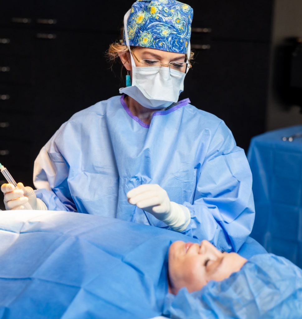 Dr. Holly Casey Wall wearing surgical garb, operating on a patient