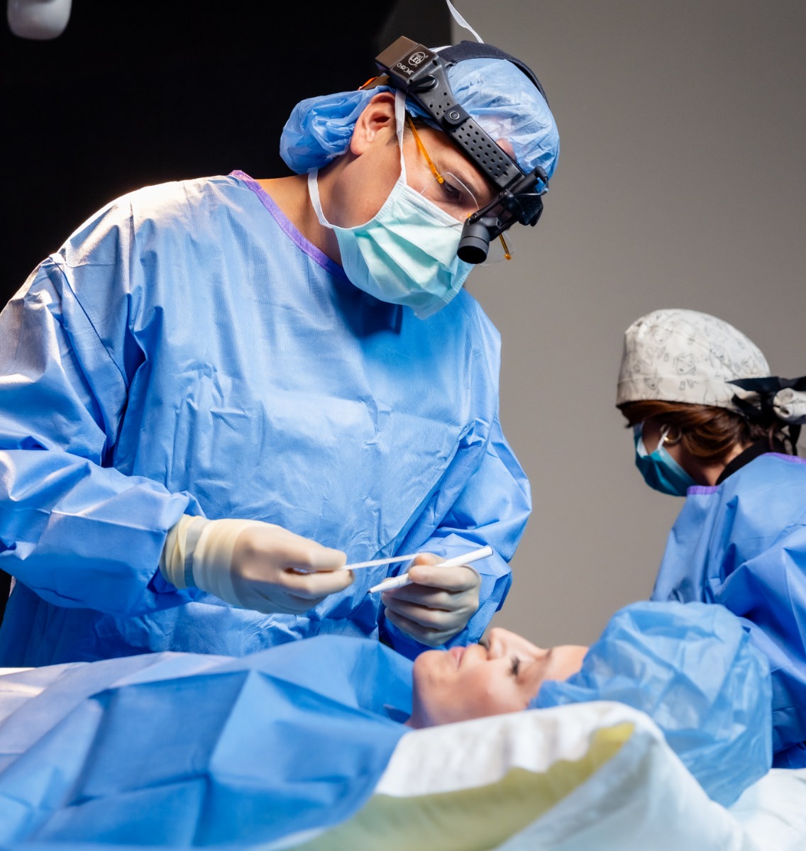 Dr. Simeon Wall Jr. wearing surgical garb, making marks on a patient before surgery