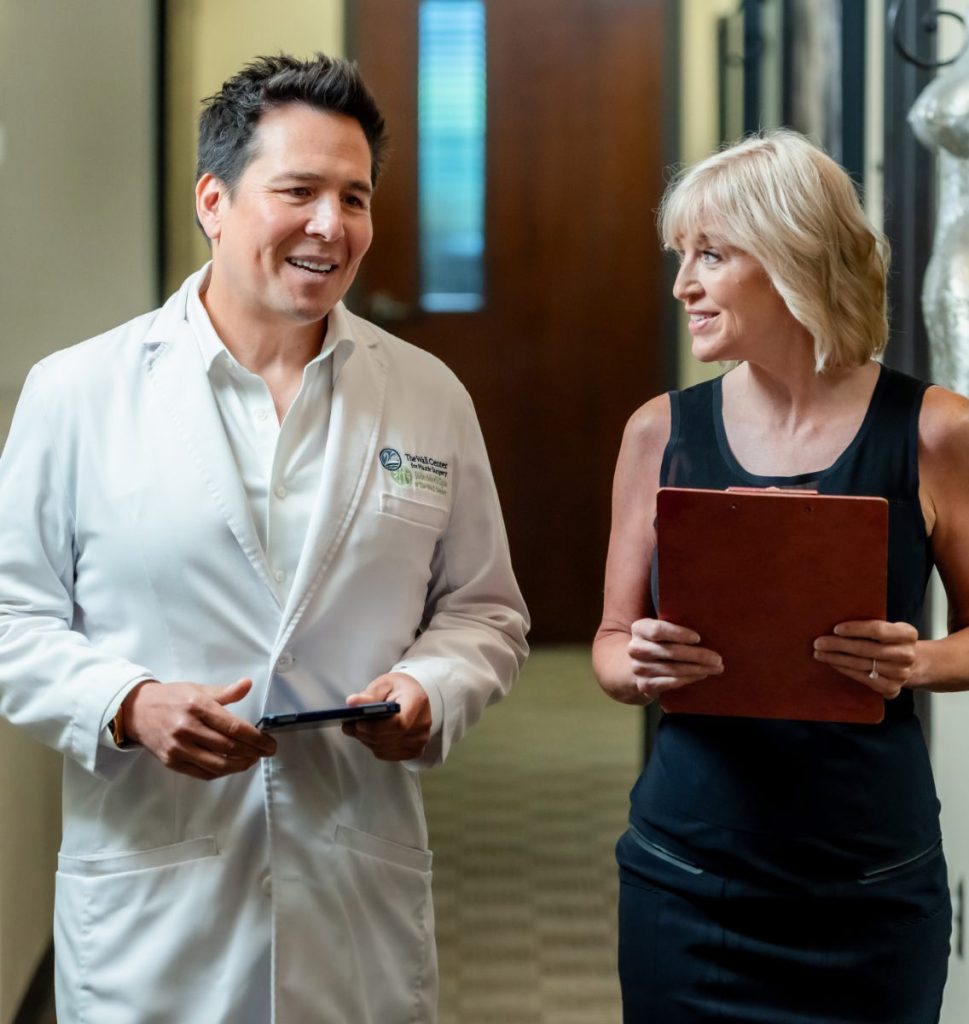 Dr. Simeon Wall Jr. walking down hall while talking to patient