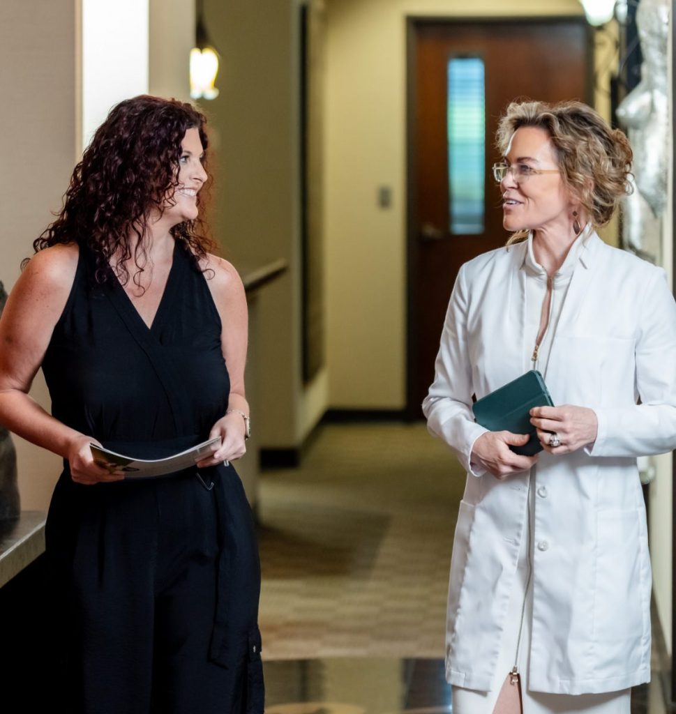 Dr. Holly Casey Wall walking down hall while talking to patient