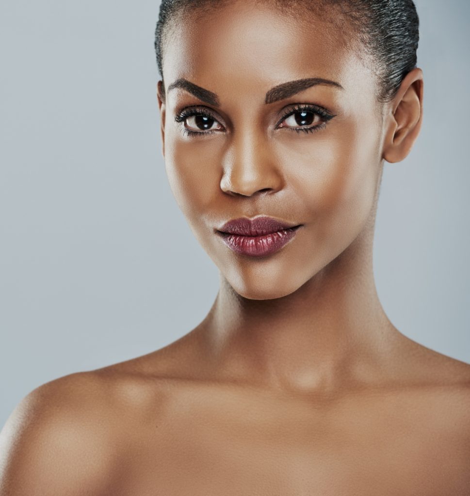 Woman with short cropped hair and brown eyes featuring radiant skin and defined facial features